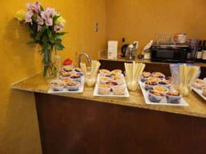 Several trays of snacks in single-serving cups laid out on a hotel room counter.
