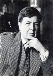 Black and white photo of Nicholas Stuart Gray, a man with short dark hair, wearing a checkered three-piece suit and posing with his hand on his chin.