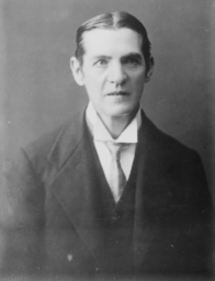 Black and white photo fro around 1915 of Irene Clyde/Thomas Baty, a white person with short dark hair wearing a dark suit.