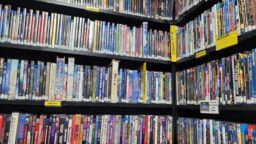 A closer view of one corner of shelving, showing four shelves packed with fantasy and science fiction Blu-rays, DVDs, and videocassettes.