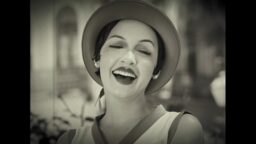 Still from Catty Bete, a black and white shot of a smiling woman in 1920s or 1930s clothing.