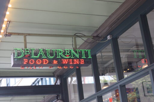 The red and green neon DeLaurenti Food and Wine sign outside the store.