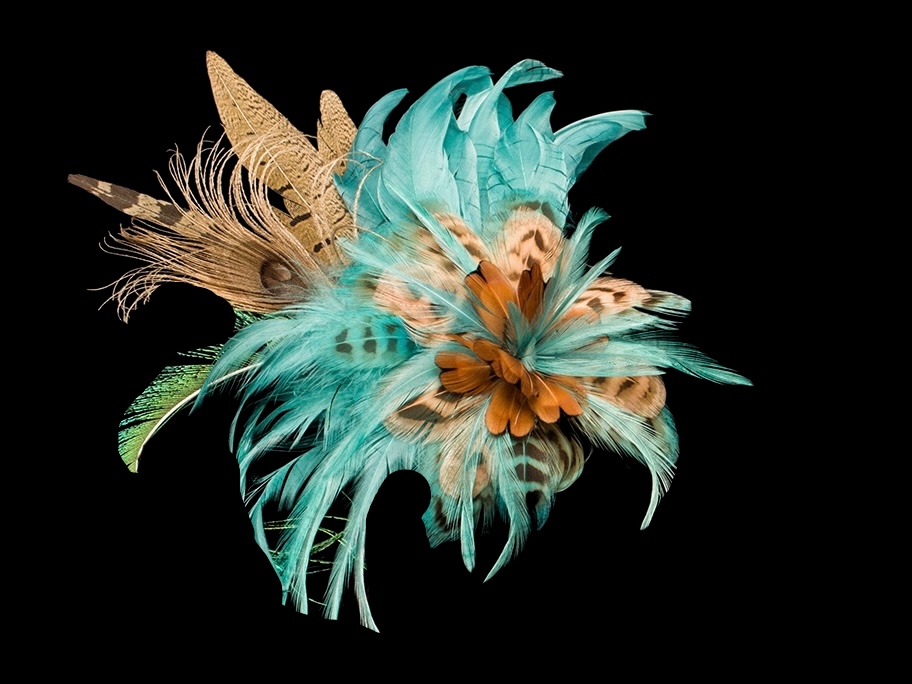 This is a photo of a feather flower that can be worn in the hair, hat, or anywhere. It is a soft aqua with touches of natural feathers. It is three dimensional like a flower and can be steamed to help the feathers find their memory. Feathers are a beautiful medium.