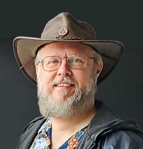 Picture of artist Laszlo Jay, wearing a bush hat and Hawaiian shirt. He has glasses and a beard.