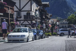 A street in Leavenworth, with traditional Bavarian style buildings and green mountains in the distance.