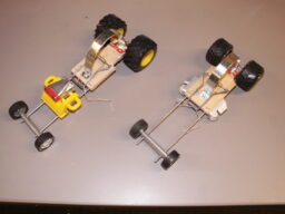 Two kinetic sculptures, wheeled contraptions made of bits of toy cars and mousetraps.