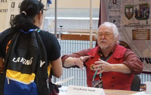 A con member visiting a club table in the Exhibition Hall