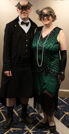 Guests in formal dress and decorative masks. 