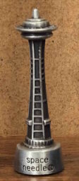 Image of a die cast Space Needle with the words 'space needle ®' engraved on the bottom.